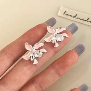Nahaufnahme von rosa Emaille-Orchideenohrringen mit Zirkonia auf Silbermetall