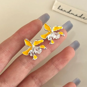 Detailaufnahme gelber Blumenohrstecker mit weißem Zirkonia und Emaille-Oberfläche