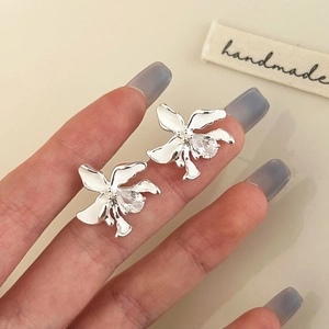 Nahaufnahme der handgefertigten Blumenohrstecker mit Zirkon im Tropfenschliff