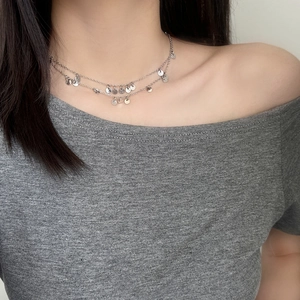 Double-layer silver necklace with sequins on a model for a chic clavicle style