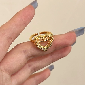 Bague cœur évidé dorée avec texture sablée élégante portée par un mannequin de main