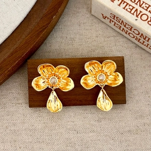 Detailed view of vintage gold flower earrings with crystals and water-drop pendants
