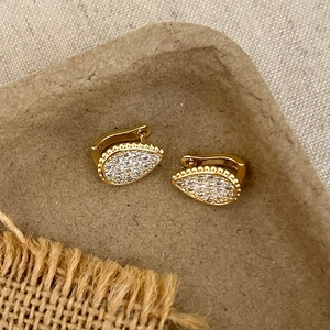Detailed view of teardrop pavé earrings in gold finish with micro-set zircon stones