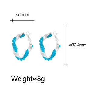 Detailed view of silver twisted hoop earrings with blue crystals and size markings