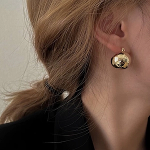 Minimalist polished golden ball stud earrings shown on model for a classic look
