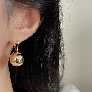 Minimalist French style polished gold sphere drop earrings with reflective mirror finish
