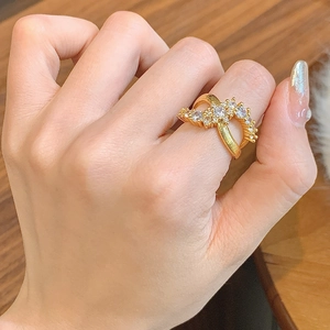Detailed view of elegant double-layered gold crossover ring with sparkling zircon stones