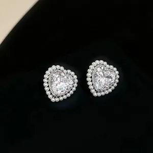 Elegant heart-shaped pink zircon stud earrings with pearl halo on black display