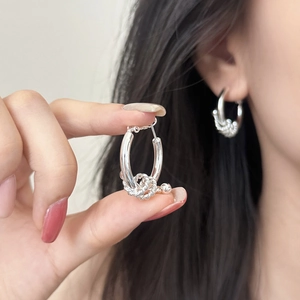 Orecchini a cerchio intrecciati in argento con dettaglio di perla in metallo