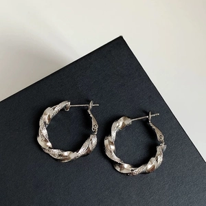 Vue détaillée de boucles d'oreilles Mobius argentées avec finitions mates et polies