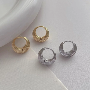 Polished gold and silver textured hoop earrings featuring a modern layered ridge design