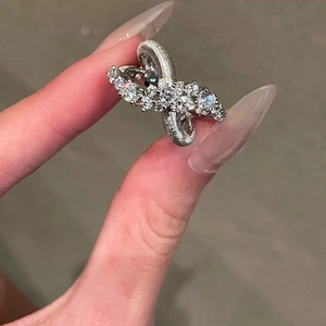 Elegant silver crisscross open ring with brilliant cubic zirconia on neutral background