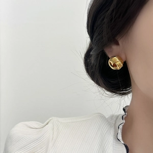 Elegant gold twisted knot earrings for women shown on model for daily fashion wear