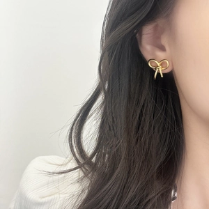 Elegant gold bow earrings with a unique twisted rope texture for a minimalist stylish look