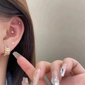 Elegant gold leaf hoop earrings with sparkling cubic zirconia on a female model