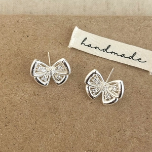 Boucles d'oreilles nœuds argentées avec ailes en filigrane et accents en zircon étincelant