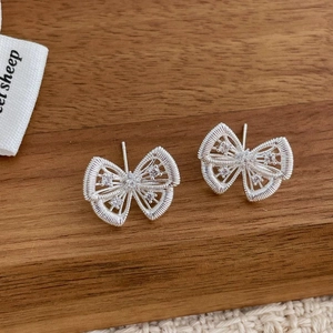 Détails macro des boucles d'oreilles nœuds vintage français avec zircons et textures fines