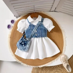 Flat lay of girl's puff sleeve shirt dress with denim vest and matching bow bag