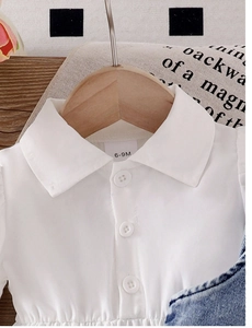 Detail of white cotton baby dress featuring a classic collar and 6-9M size label