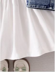 Detail of white pleated puff sleeve dress paired with blue denim vest and bow shoes