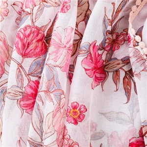 Détail d'une écharpe fleurie avec fleurs roses et bordure en dentelle beige délicate