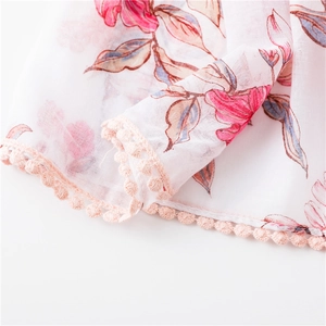 Détail de l'écharpe en coton et lin à fleurs avec bordure de dentelle à pompons