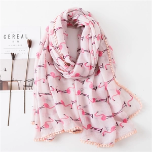 Détail du foulard rose à motif flamant rose avec bordure en dentelle à pompons doux