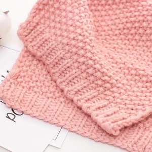 Close-up of pink knitted baby scarf texture with soft warm wool stitching details