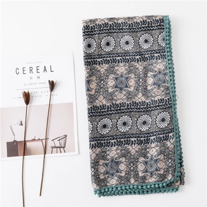 Détail de châle au motif vintage avec pompons turquoise et imprimés de feuilles