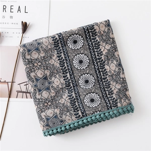 Détail d'une écharpe mandala bohème avec bordure pompon vert et texture coton doux