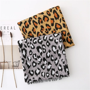 Close-up of leopard print scarves in orange-brown and grey with fine tassel details