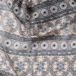 Vue macro du tissu léger avec motifs floraux vintage et géométriques sur l'écharpe
