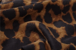 Gros plan détaillé sur la texture léopard douce et les franges délicates du foulard