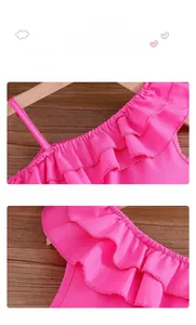 Detail of pink ruffled dress showing round neckline and elastic cuffs on wood hanger