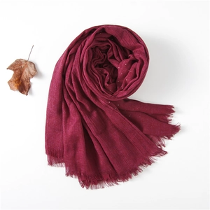 Close-up of deep wine red cotton linen scarf with rhinestone accents and fringe edges