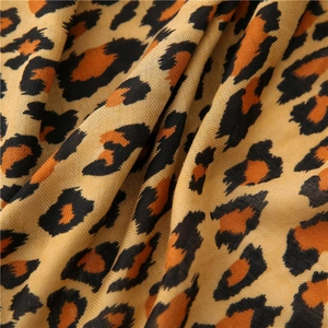 Long leopard print scarf featuring twill weave fabric in orange and earth tones