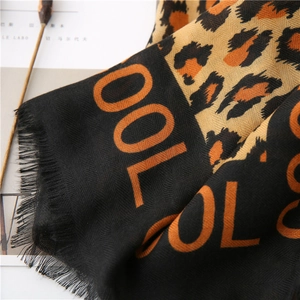 Macro detail of leopard print scarf with COOL lettering and delicate fringe edges
