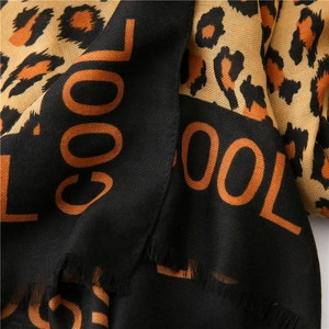 Detail of leopard print scarf with COOL lettering and herringbone woven texture