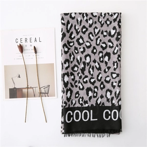 Detail of leopard print scarf with 'COOL' text border and handmade fringe edges