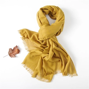 Detail of mustard yellow cotton linen scarf with white polka dots and fringe edges