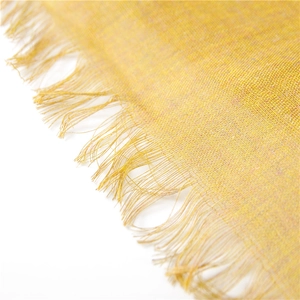 Close-up of bright yellow cotton linen scarf with soft fringe and fine texture