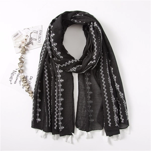 Detail of black cotton linen scarf featuring white ethnic embroidery and fringe edges