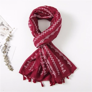 Close-up of dark red cotton linen scarf with white cross geometric patterns and tassels