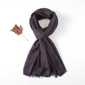 Detail of dark purple polka dot scarf with frayed edges and soft cotton texture