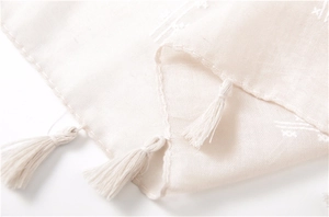 Detailed macro view of cotton linen shawl texture with delicate fringe tassel edges