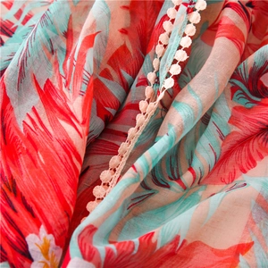 Détail d'un châle en coton et lin à imprimé tropical avec bordure dentelle blanche