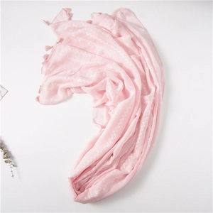 Detail of light pink cotton linen scarf with white embroidery and tassel fringe edges