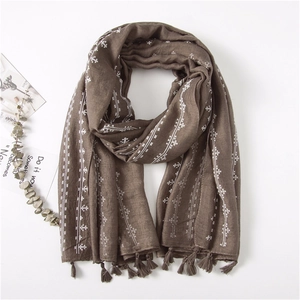 Close-up of coffee brown cotton linen scarf with white cross stitching and fringe details