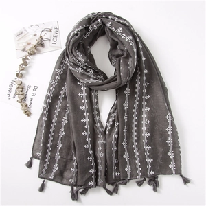 Detail of dark grey cotton linen scarf with white geometric cross-stitch and fringe trim