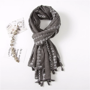 Detail of dark grey cotton linen scarf with white cross patterns and fringe tassels